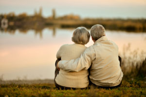senior couple sitting by the lake
