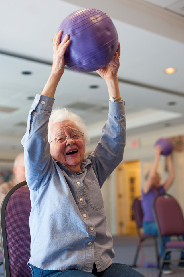 A senior at Bel Air Assisted Living partaking in wellness activities to strengthen her muscles