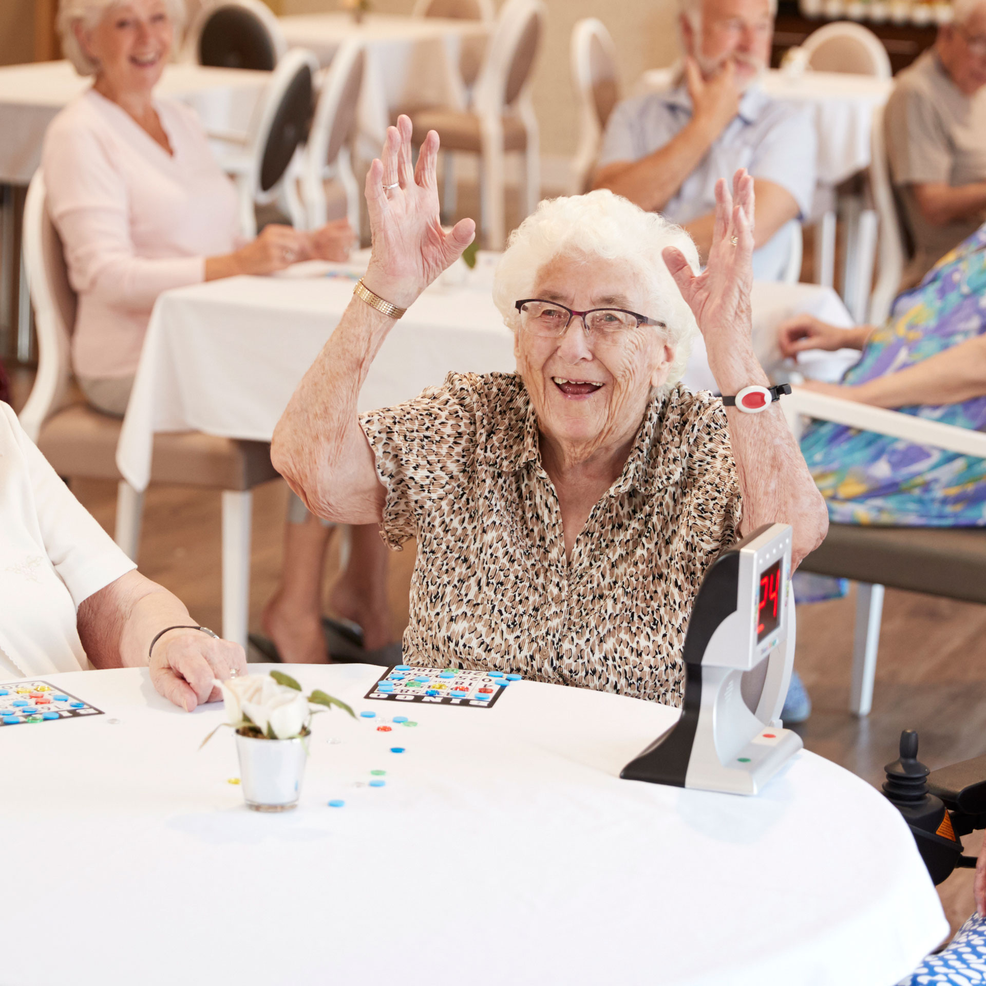 An elderly woman having fun while playing a game at Bel Air Assisted Living