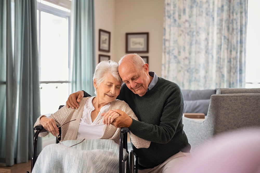 Nurse Helping Senior Man A smiling senior couple sits with a Bel Air Assisted Living staff member reviewing their assisted living checklist before move-in day.