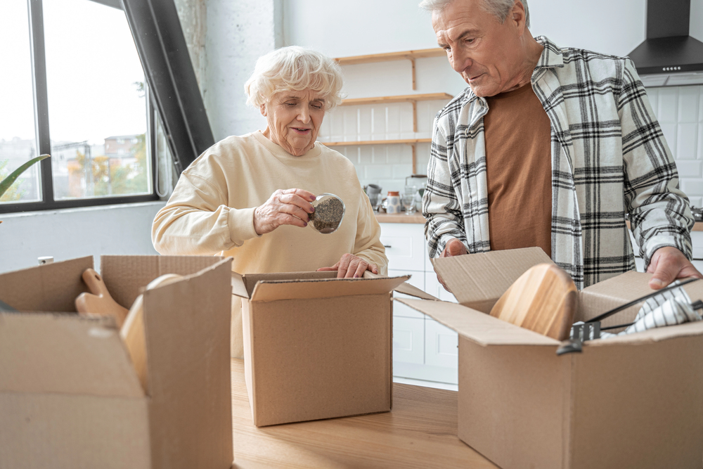 Happy retired senior couple moving into a new home and unpacking boxes A cozy new living space decorated with family heirlooms, showing a sunlit dining room and personal touches that reflect a welcoming senior lifestyle.